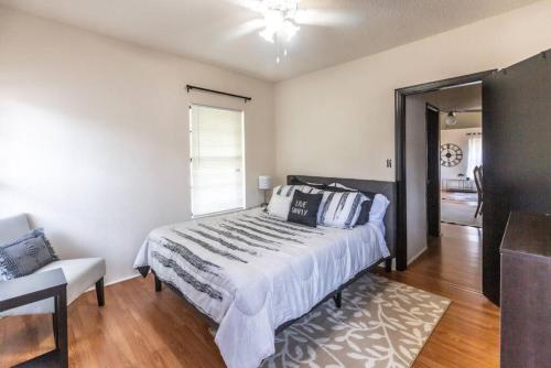 a bedroom with a bed and a chair and a window at Trailside Retreat in the City in Tulsa