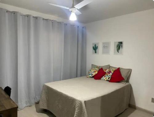 a bedroom with a bed with a ceiling fan at Apartamento aconchegante com 03 quartos ideal para familia ou turma in Diamantina