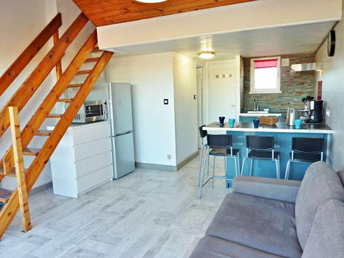 - un salon avec une cuisine et un escalier dans une maison dans l'établissement Duplex rénové avec clim, terrasse et parking à Marseillan - FR-1-387-162, à Marseillan