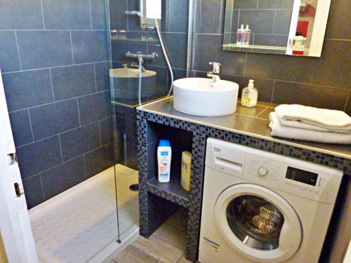 ein Badezimmer mit einer Waschmaschine und einem Waschbecken in der Unterkunft Appartement Marseillan-Plage, 2 pièces, 4 personnes - FR-1-387-162 in Marseillan
