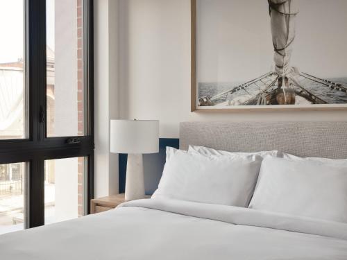 a bedroom with a white bed and a window at Hôtel Expérience - Quartier Des Marinas in Magog-Orford