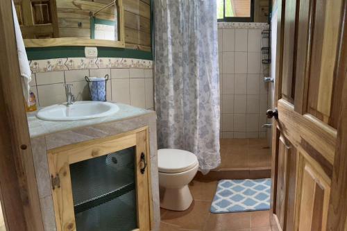 ein kleines Bad mit einem Waschbecken und einem WC in der Unterkunft CASITAS GINGER in Quepos
