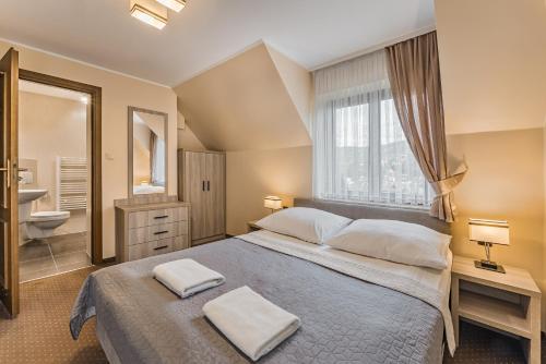 1 dormitorio con 1 cama grande y baño en Willa Urocze, en Szczawnica