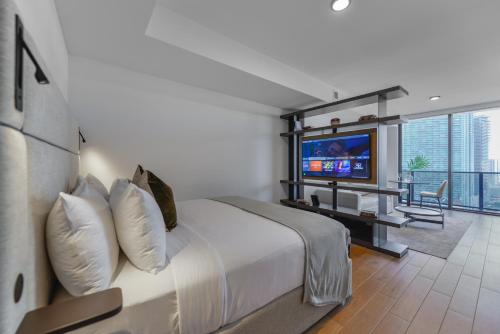 a hotel room with a bed and a television at Elegance and Charm Studio at Bayside Miami in Miami