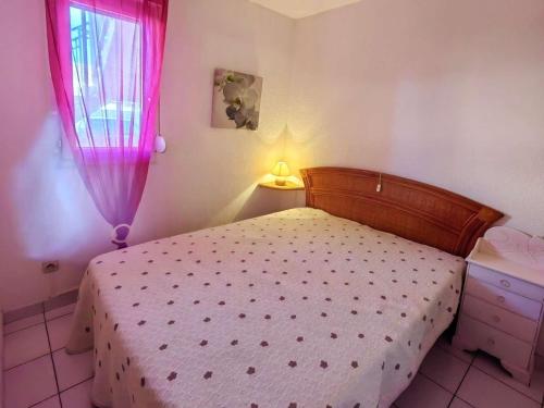 une chambre avec un lit et une fenêtre dans l'établissement T2 climatisé en rez-de-jardin avec piscine, parking, et terrase. Plage à 450m, WiFi gratuit. - FR-1-607-52, au Cap d'Agde