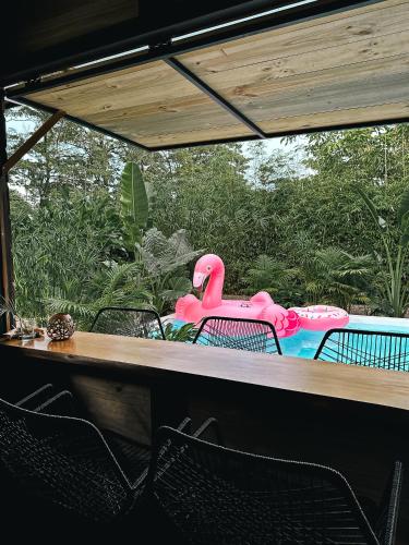 a table with chairs in front of a pool at Kanoa Lodge - Adults and 18 plus only in Pavones
