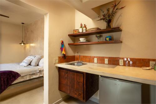 a kitchen with a sink and a bed in a room at Hotel Hondo in Los Barriles