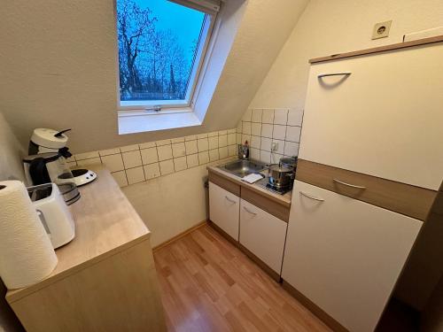 uma pequena cozinha com um lavatório e uma janela em Modern Apartment in Gütersloh Avenwedde em Gütersloh