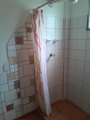 a shower with a shower curtain in a bathroom at Hostal Hansi in Bocas del Toro