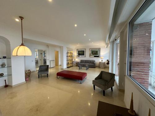 ein großes Wohnzimmer mit einem roten Sofa und Stühlen in der Unterkunft Luxury Posillipo Capri View Apartment in Neapel