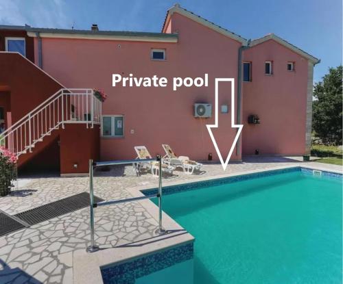 a villa with a pool and a house at Poolside Paradise in Srijane