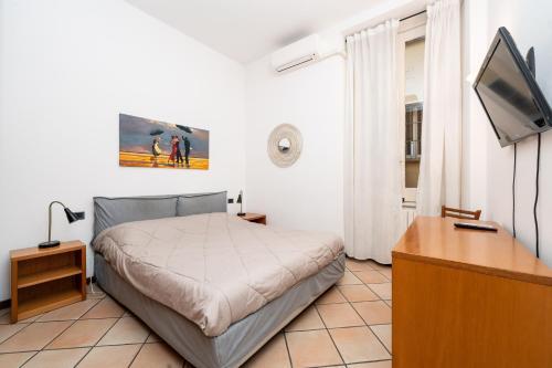 a bedroom with a bed and a desk and a tv at CASEMI - Mercato 16 SX IN FULL CITY CENTER in Milan