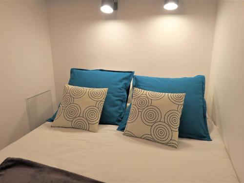 un lit avec deux oreillers bleus dessus dans l'établissement Bel appartement rénové face au port avec loggia et garage privé à Perros-Guirec - FR-1-368-283, à Perros-Guirec