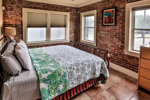 een slaapkamer met een bed in een bakstenen muur bij The Teak Follow, beautiful brick enclosed space in Tulsa