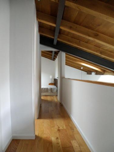 an empty hallway with wood ceilings and a bedroom at Casa de las Flores / Casa de campo LUGO in A Pontenova