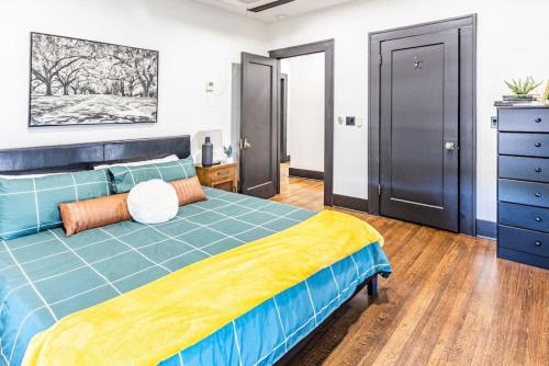 een slaapkamer met een blauw bed en een dressoir bij Pleasantly Plush - Quality and Comfort Downtown in Tulsa