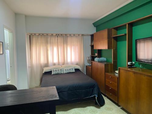- une chambre avec un lit et une télévision dans l'établissement Departamento frente al Mar Necochea, à Necochea