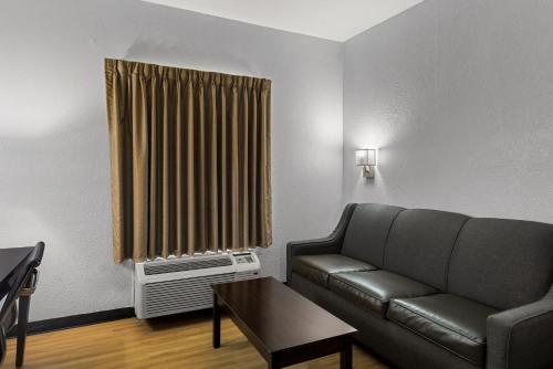 a living room with a couch and a window at Clarion Pointe Hinesville near Fort Stewart in Hinesville