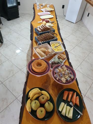 una mesa larga llena de diferentes tipos de alimentos en Dein Platz Pousada, en Timbó