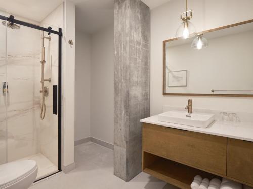 a bathroom with a sink and a shower at Hôtel Expérience - Quartier Des Marinas in Magog-Orford