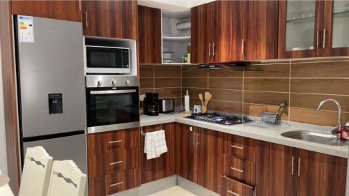 a kitchen with wooden cabinets and stainless steel appliances at RESIDENCE ABBAS in Yaoundé