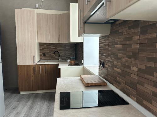 a kitchen with wooden cabinets and a brick wall at Centralnyi hotel in Poltava