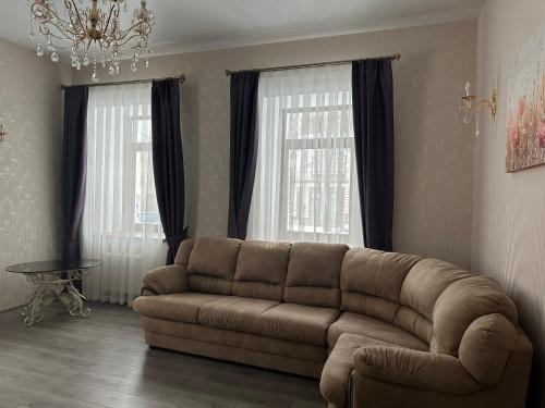 a living room with a couch and two windows at Centralnyi hotel in Poltava