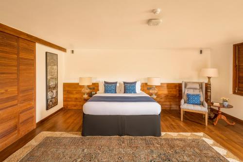 a bedroom with a bed and a chair at Ishq Colombo in Colombo