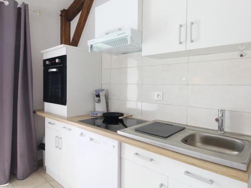a small kitchen with a sink and a microwave at Gîte cosy avec spa privatif, terrasse et parking, au cœur des vignobles du Layon, idéal pour couples. - FR-1-622-21 in La Viardière