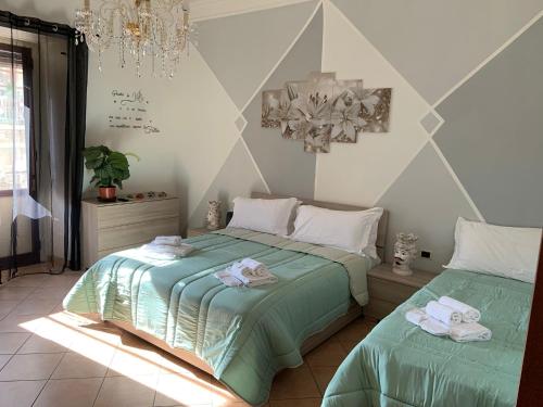 a bedroom with two beds and a chandelier at The Crazy House in Catania
