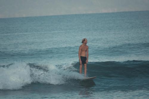 a man riding a wave on a surfboard in the ocean at Kanoa Lodge - Adults and 18 plus only in Pavones