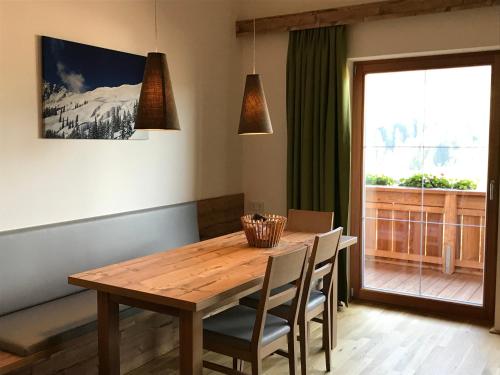 a dining room table with chairs and a window at Ferienwohnung Neubau in Alpbach