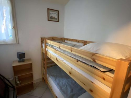 un lit superposé en bois dans une petite pièce dans l'établissement Villa mitoyenne climatisée, calme avec piscine et parking, proche plage et port, pour 6 personnes - FR-1-607-125, au Cap d'Agde