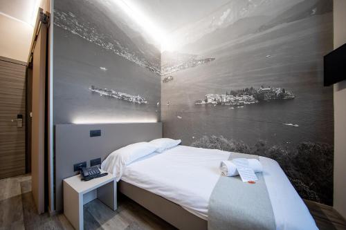 Cette chambre comprend un lit orné d'une peinture murale. dans l'établissement Hotel Novara, à Verbania
