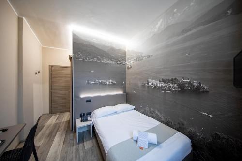 Hotel Novara في فيربانيا: غرفة نوم بسرير مع لوحة على الحائط
