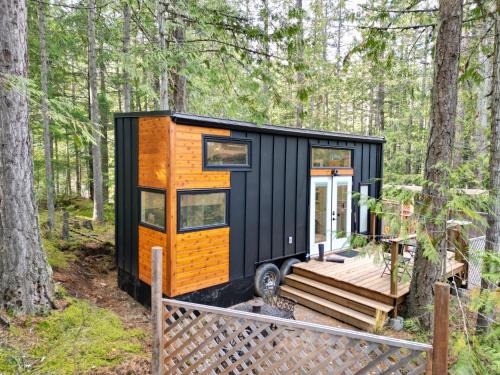 a black and orange tiny house in the woods at Cliffside Hideaways 