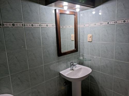 bagno con lavandino e specchio di Los Lirios de Dayman a Termas del Daymán