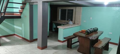 Baloy beach house في اولونجابو: مطبخ مع حوض وطاولة في الغرفة