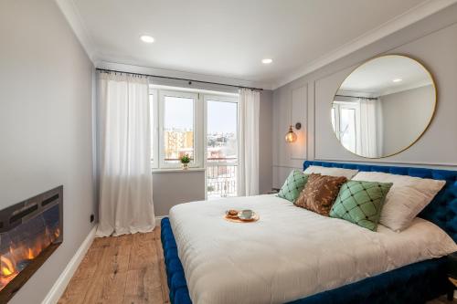 a bedroom with a bed with a mirror and a fireplace at BOMBONIERKA Apartamenty in Krynica Zdrój