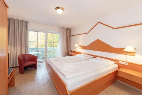 um quarto de hotel com uma cama e uma cadeira em Aschau-Apartments em Aschau im Chiemgau