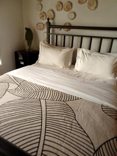 1 cama grande con edredón blanco y negro en Saffier river cottage Farmstay en Lady Grey