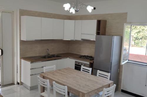 a kitchen with a wooden table and a refrigerator at Dimora Elisabetta casa a pochi passi dal mare in Pontecagnano