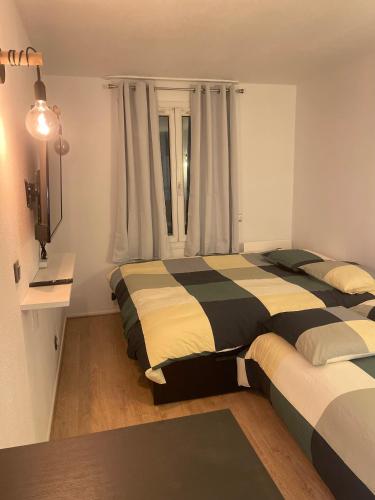 une chambre avec deux lits et un bureau et une fenêtre dans l'établissement T2D Apartment - Suite UR proche Disneyland Paris, à Bussy-Saint-Georges