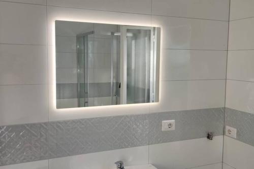 ein Badezimmer mit einem Spiegel und einem Waschbecken in der Unterkunft Dimora Elisabetta casa a pochi passi dal mare in Pontecagnano
