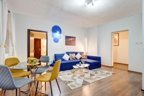 a living room with a blue couch and a table at Holiday Apartments Bucharest in Bucharest