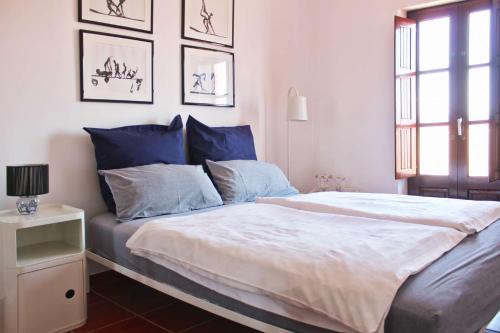 a bedroom with a large bed with blue and white sheets at Penthouse Alentejana in Vila Nova de Milfontes