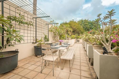 a patio with tables and chairs and potted plants at Ishq Colombo in Colombo