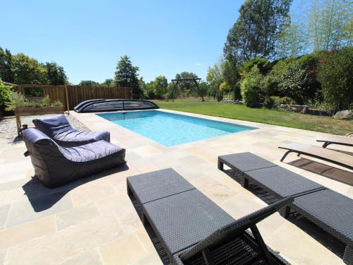 a swimming pool with two chairs and a table at Gîte moderne avec piscine en Anjou, proche Saumur et Cholet, idéal pour familles et groupes - FR-1-622-30 in Vihiers