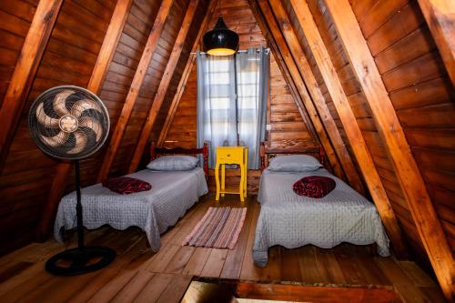 um quarto com 2 camas num chalé de madeira em CHALE DAS ESTRELAS em Piçarras