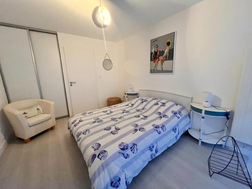 une chambre avec un lit et une chaise dedans dans l'établissement Appartement 3 pièces à 100m de la plage avec grande terrasse et WIFI – Les Sables-d'Olonne - FR-1-197-537, à Les Sables-dʼOlonne
